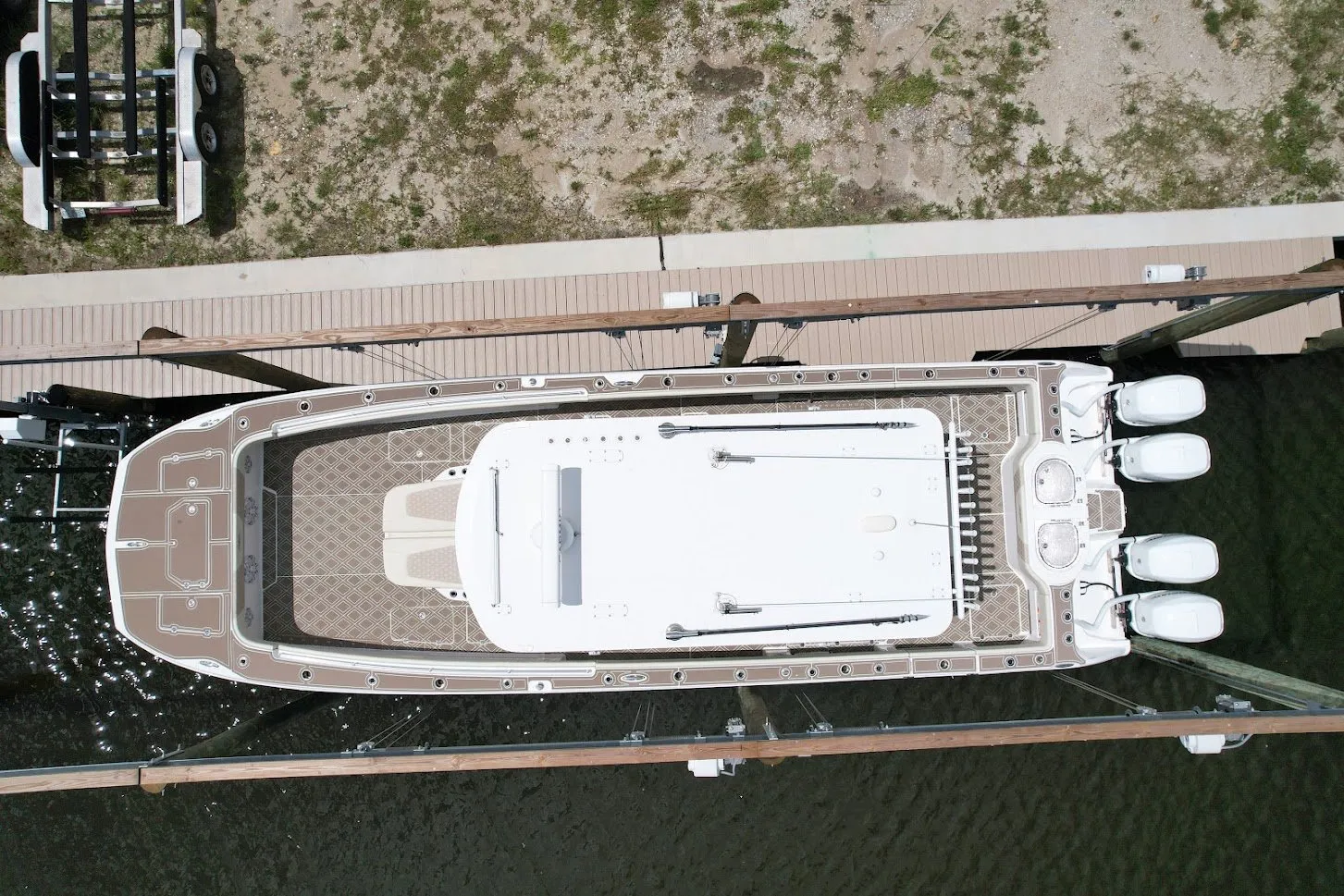 Aerial view of a large boat with custom detailing on a lift, surrounded by a modern dock.