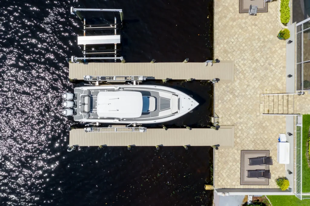 Aerial view of a docked boat with triple outboard motors and a tiled patio area.