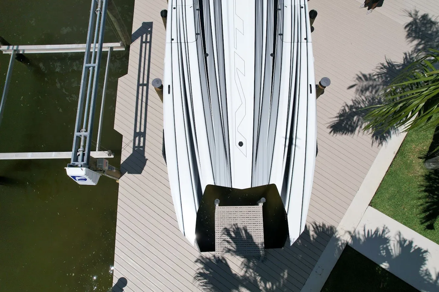 A close-up view of a sleek boat secured on a custom dock with a modern lift system.