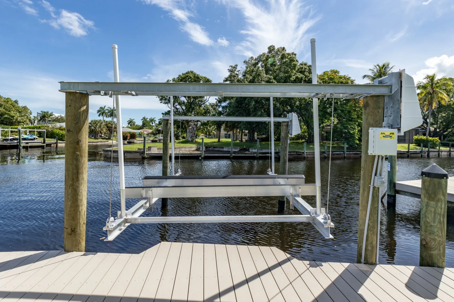 Close-up of a boat lift on a dock overlooking a peaceful canal.