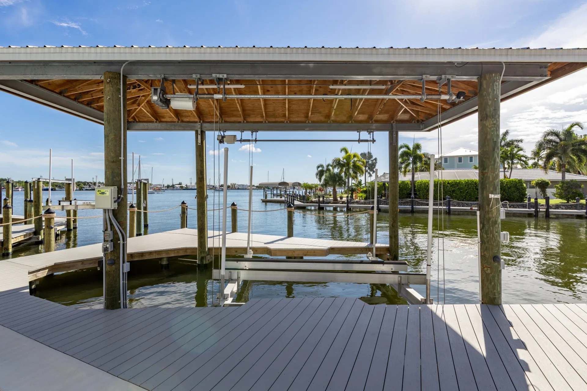 Covered boat lift dock with a waterfront view under clear skies.