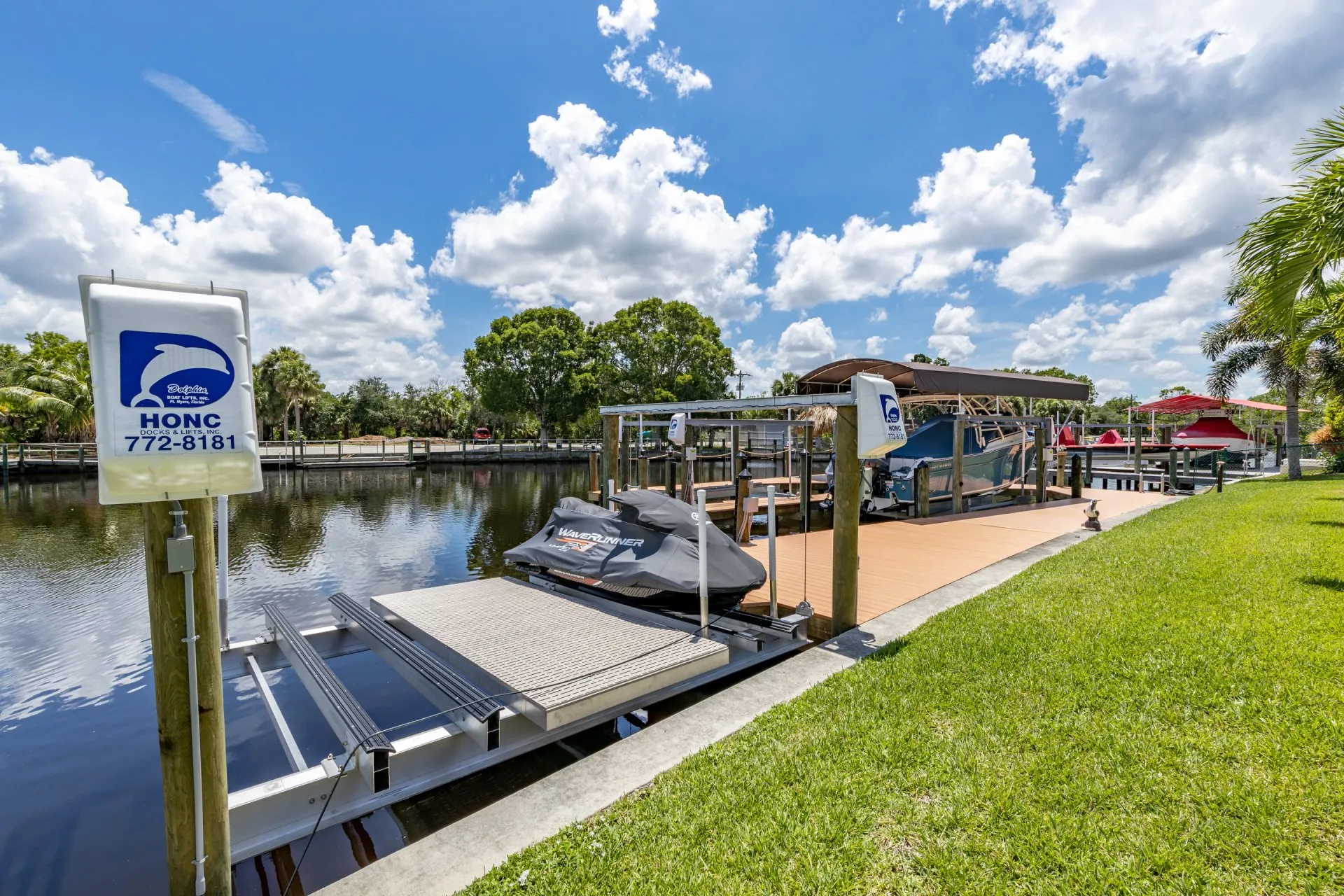 A jet ski on a lift by Honc Docks & Lifts, set along a calm residential canal.