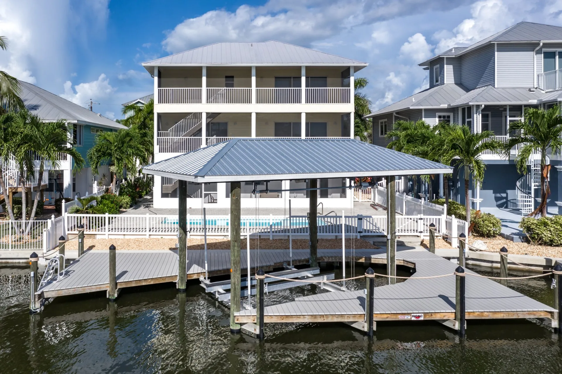 A modern waterfront home with a covered dock and boat lift. Title: Waterfront Home with Covered Dock and Boat Lift