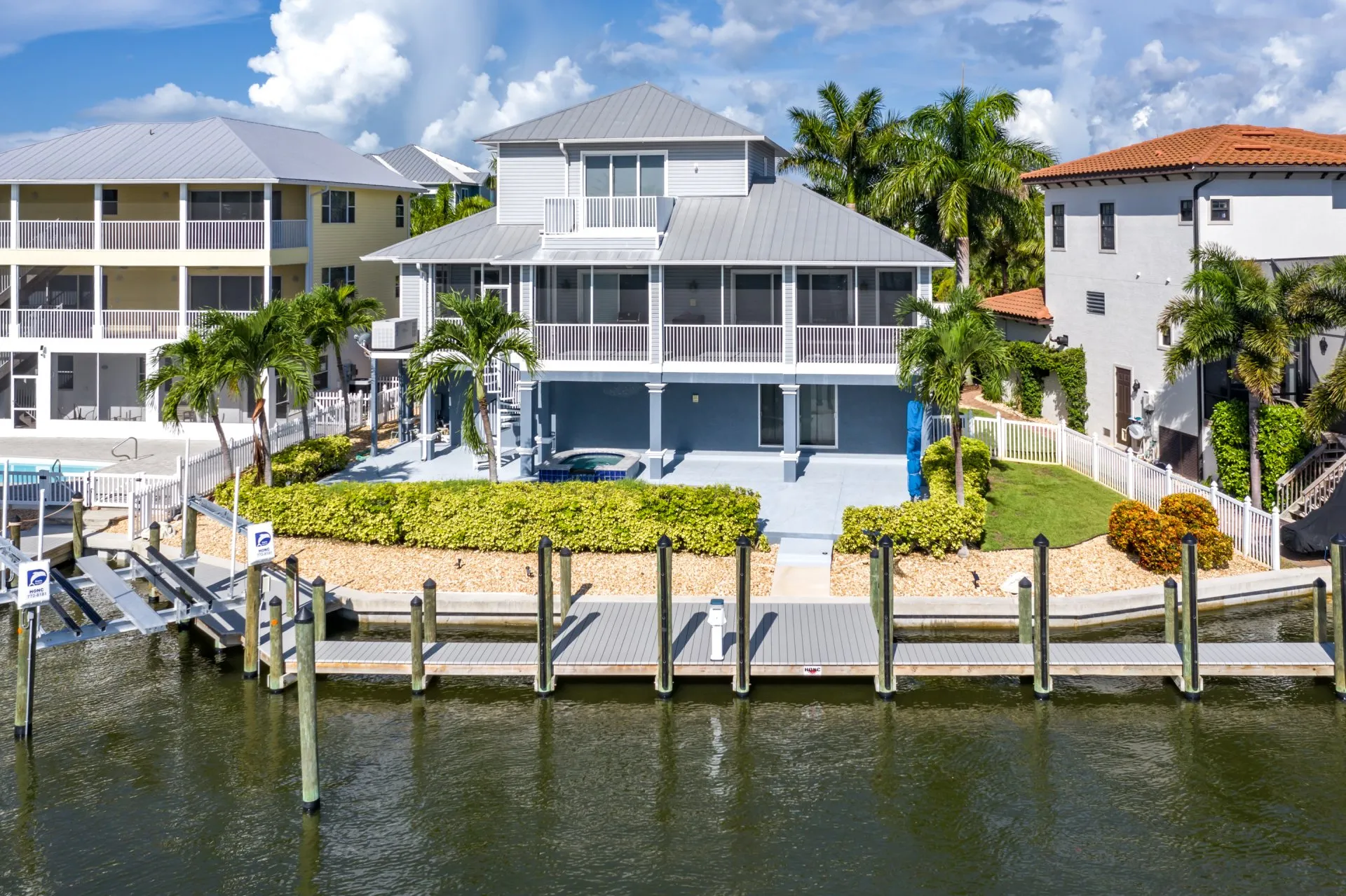 A modern waterfront home with a private dock and a lush landscaped yard.