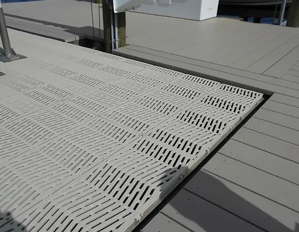 Close-up of a white grated dock platform accessory installed on composite decking.