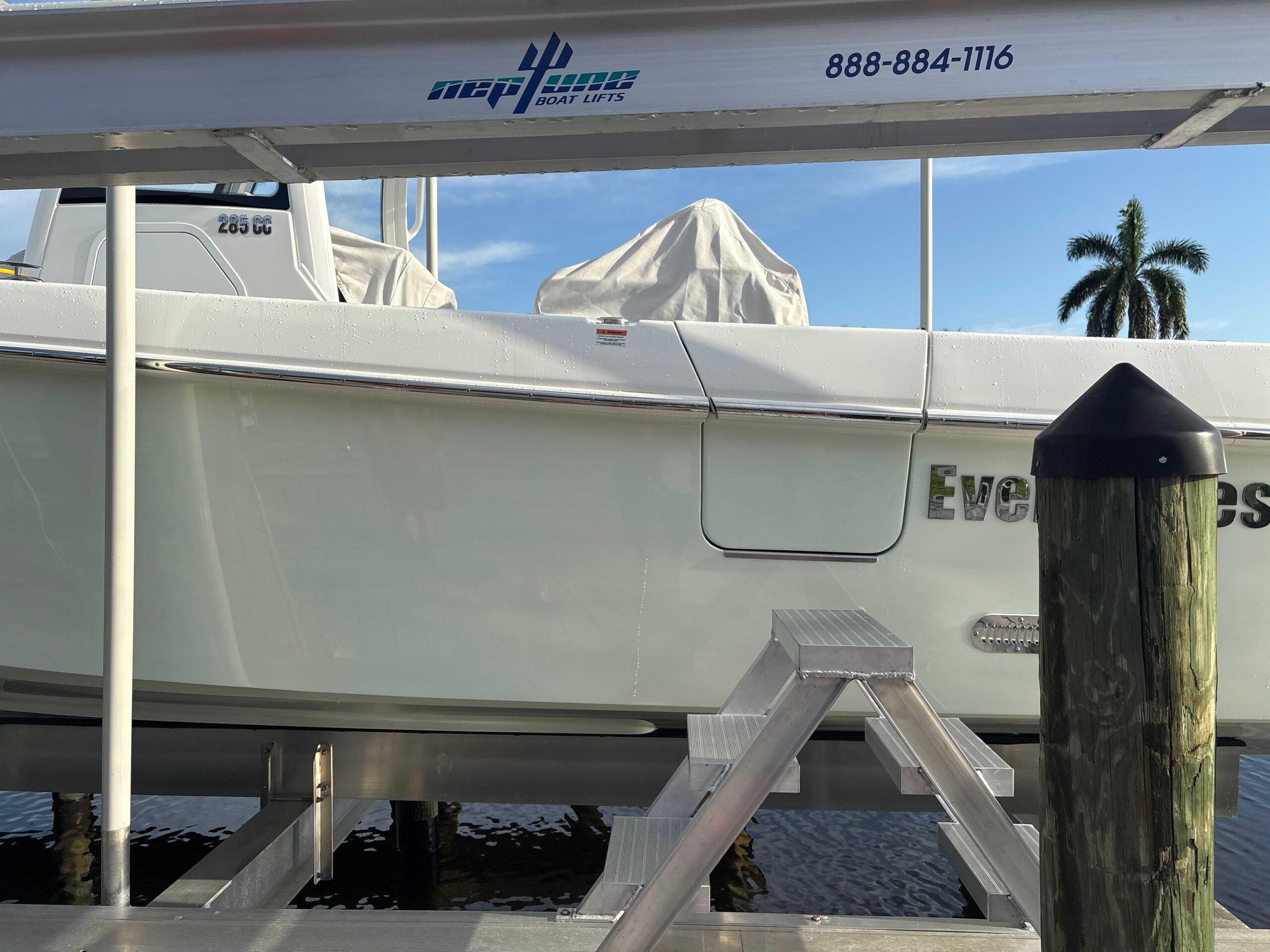 Aluminum access ladder and walkway leading to a raised boat lift holding a center console boat.